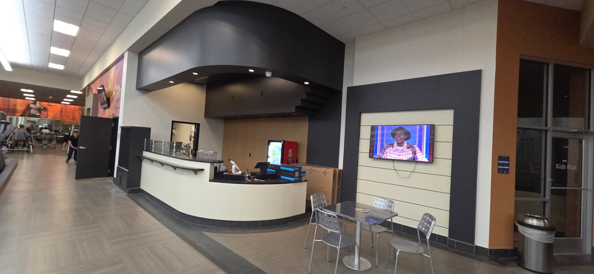 Finished commercial gym reception area with updated counter, drink cooler and seating