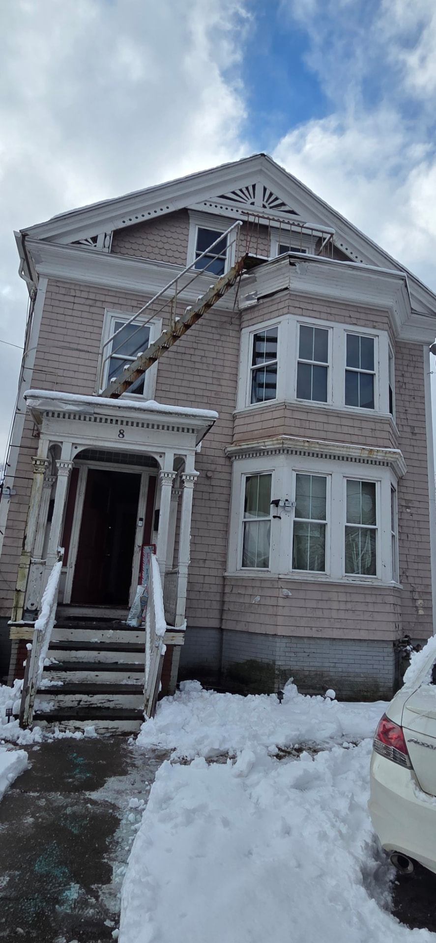 Victorian house exterior with worn, peeling paint before painting